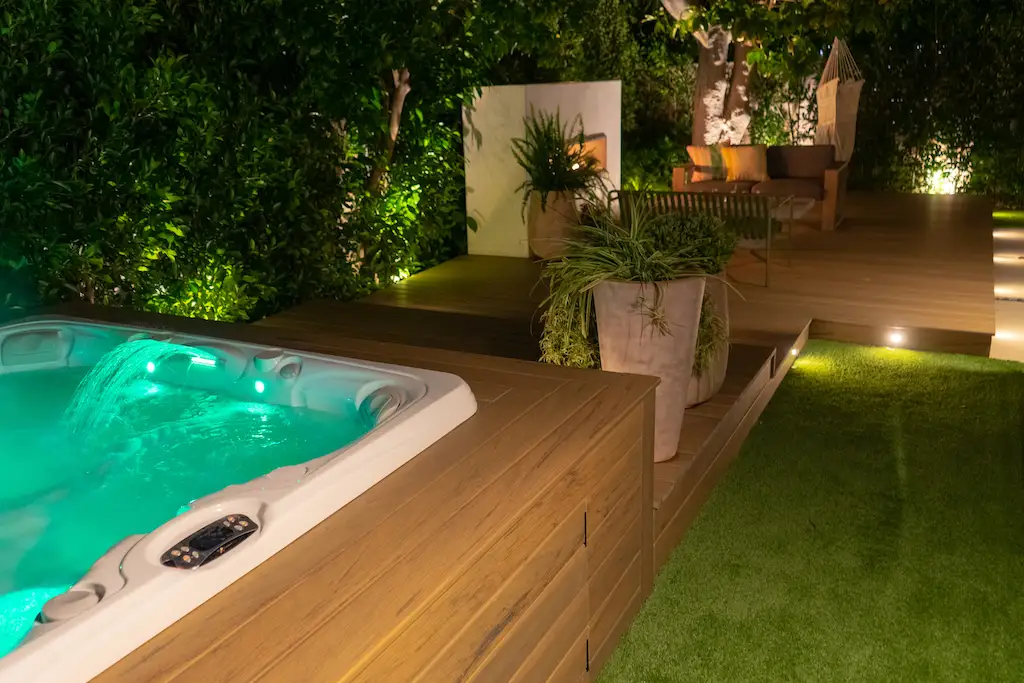 A deck by a pool with landscaping elements.